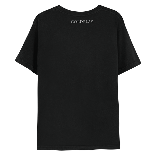2: Back: The shirt is black. COLDPLAY is printed in white, just below the neckline. MUSIC OF THE SPHERES is written on the right sleeve. The band name is in a classic, elegant font, with small decorative lines or strokes at the ends of the letters