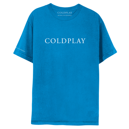 Front: COLDPLAY is printed in large, white font, across the chest of a blue T-shirt. MUSIC OF THE SPHERES is printed small on the right sleeve, near the hem. The inside label of the neckline also reads MUSIC OF THE SPHERES. The shade of blue of the shirt is a standard blue, not greenish, as you would expect from teal. The blue is slightly darker than the shade of the sapphire edition