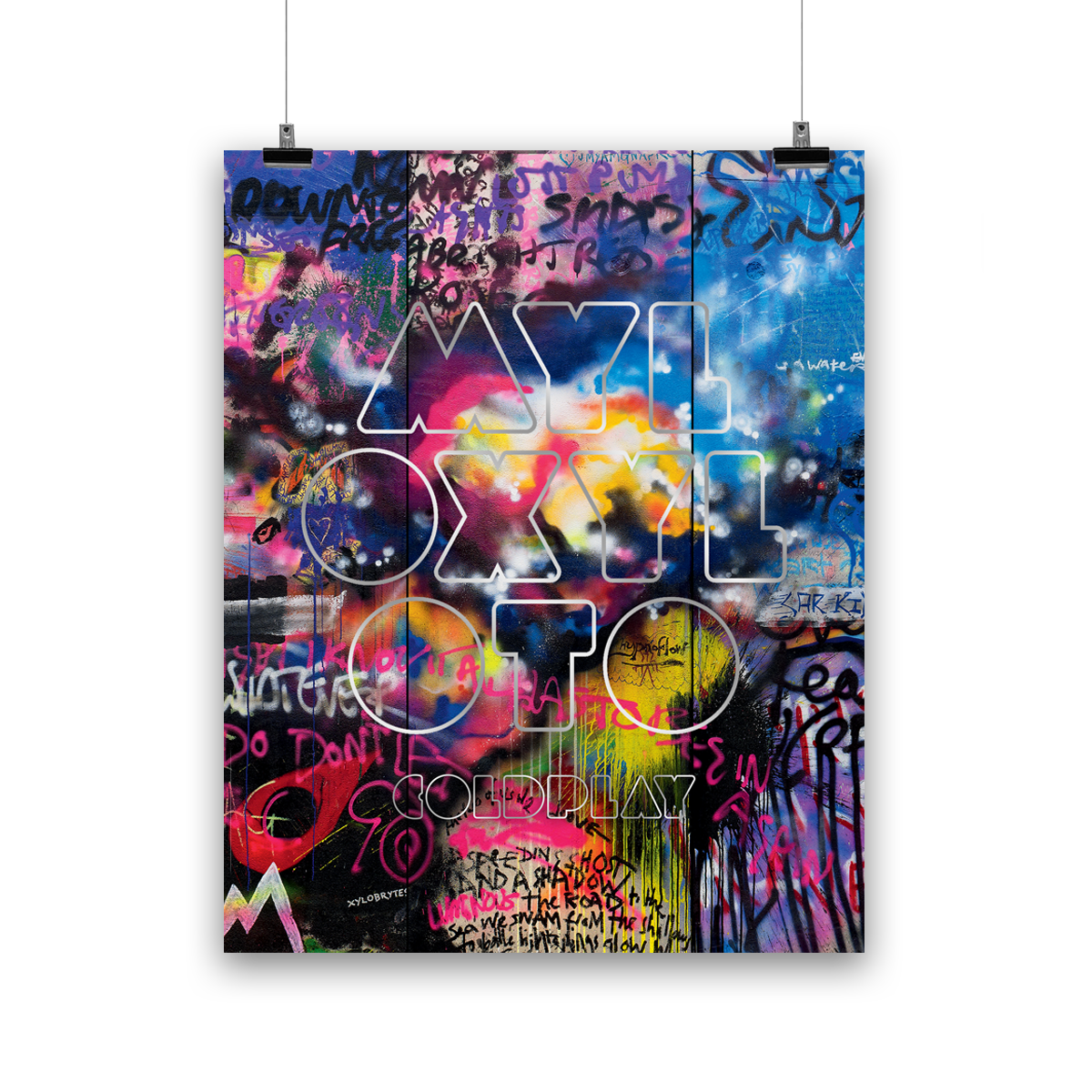 GraffitiWall with darkGreen,  neonYellow, red, blue, purple, beige&orangePatches. A cloudLikeCollection of white, yellow, orange, brightPink&magenta looks like aHeartHadOnce beenThere. On a lightBlueSplotch is anOutline of a??in darkBlue. UP WITH THE BIRDS is writtenNear. We see a lightPink&darkBlueSection withWhiteBehindIt. RainbowColoredBlobs, butDuller. WhiteStripes. A darkRed???like a teardrop. A letter M like a??in lightBlue, yellow&pink. MYLO XYLOTO written inChunky, silverOutline sprayLetters