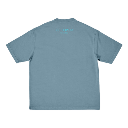 Back: COLDPLAY is printed in light blue, in a slightly lighter shade than the fabric of the shirt. Moon Music is hand-written below. COLDPLAY is larger than Moon Music.