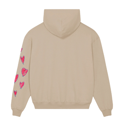 Back: This view shows the solid light beige fabric of the hoodie, and the pink fuchsia hearts outlined in purple on the left sleeve. We can also see its hood.