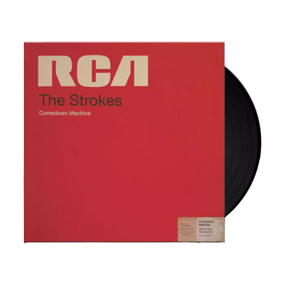 The album artwork for The Strokes' Comedown Machine with a black Vinyl poking out. The cover mimics a vintage RCA magnetic tape box, featuring a bold, textured red background and a classic, cream-colored RCA manufacturer label across the top. The album title is stamped in a minimalist, black sans-serif font across the center, giving the packaging a retro, analog media aesthetic.