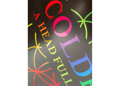 Image 3:
Lithograph text, close-up: COLDPLAY and A HEAD FULL OF DREAMS are written in a gradient of neon colors like red, fuchsia, pink, lilac, purple, blue, green, yellow and orange. Coldplay’s font is bold and large. A Head Full of Dreams is slightly smaller. The band name is above the album title